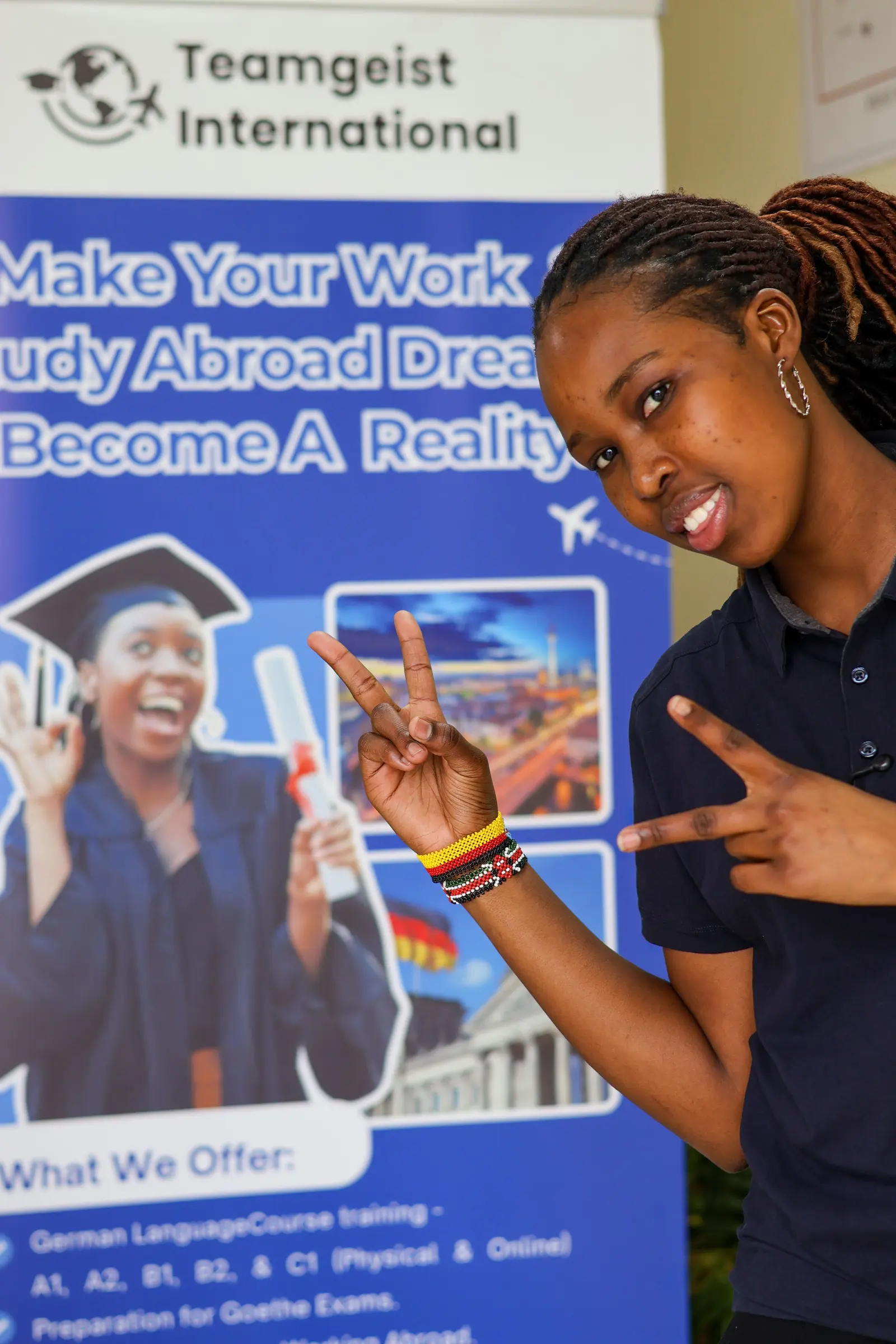 A Teamgeist International student in front of the school banner in Nairobi